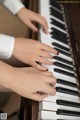 A close up of a person's hands playing a piano.