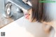 A woman is drinking water from a faucet. 