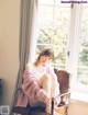 A woman sitting in a chair in front of a window.