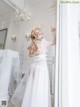 A woman in a white dress standing in a room.