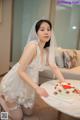 A woman in a wedding dress sitting at a table with a cake.