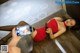 A woman in a red dress laying on the floor with a bottle of beer.