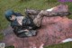 A woman laying on top of a cowhide rug in the grass.