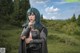 A woman with blue hair standing in a field.