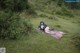 A woman laying on a blanket in a field.