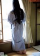 A woman standing in front of a window in a room.