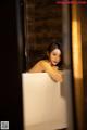 A woman sitting in a bathtub in a bathroom.