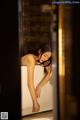 A woman leaning over a bathtub in a bathroom.