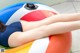 A woman laying on top of an inflatable beach ball.