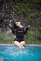 A woman sitting on the edge of a swimming pool in the snow.