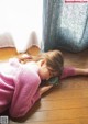 A little girl laying on the floor with her head in her hands.