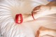 A woman's feet in red sandals on a bed.