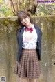 A woman in a school uniform posing for a picture.