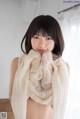 A woman wearing a white scarf is posing for a picture.