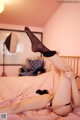 A woman laying on a bed with her legs up in the air.