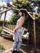 A woman standing on a wooden deck next to a white cat.