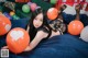 A woman laying on a bed with balloons.