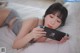 A woman laying on a bed holding a Nintendo Switch.