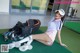 A woman sitting on the ground next to a golf bag.