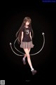 A girl in a black shirt and plaid skirt is holding a hula hoop.