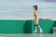 A woman in a yellow bathing suit on roller skates.