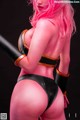 A woman with pink hair holding a baseball bat.