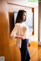 A woman standing in front of a mirror in a room.