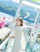 A woman standing on a bridge next to a body of water.