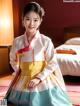 A young girl in a hanbok sitting on the floor.