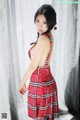 A woman in a red plaid dress posing for a picture.