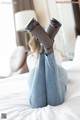 A woman laying on a bed with her legs up in the air.