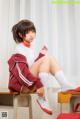 A woman sitting on top of a wooden desk.