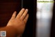 A person's hand reaching out of a wooden door.