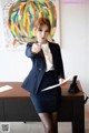 A woman in a business suit pointing at something.